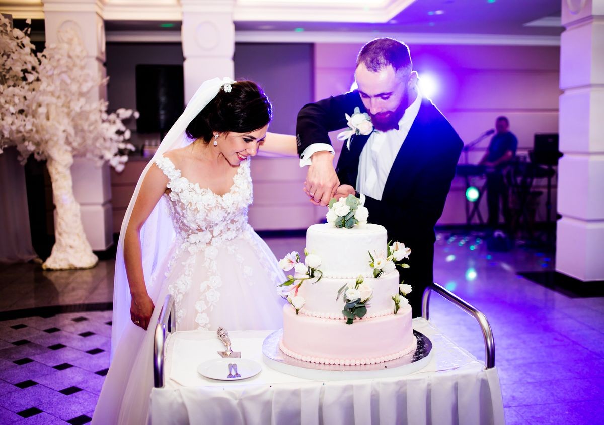 Happy bride and groom cut the wedding cake